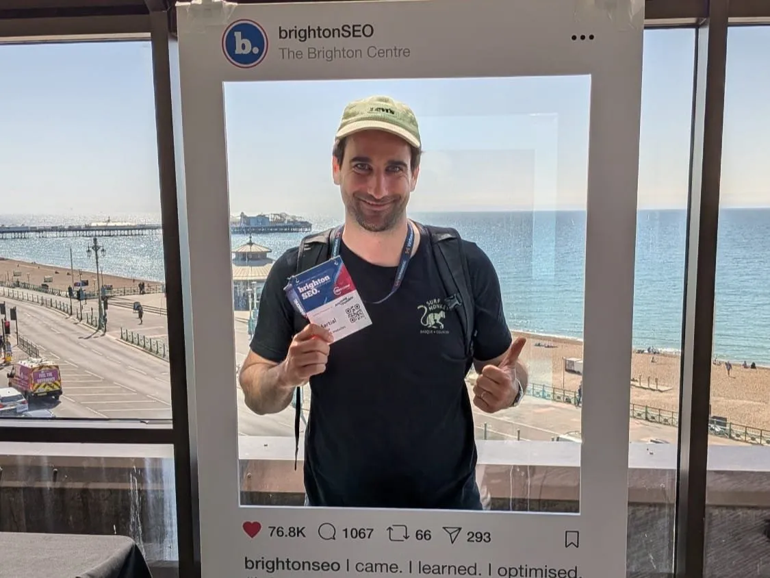 Martial at the Brighton Centre, holding up his brightonSEO pass, with the seafront behind him
